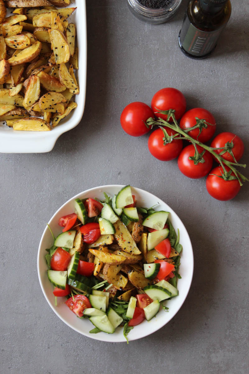 Veganer Braterdäpfelsalat mit scharfem Olivenöldressing auf Rucolabett | Blattgrün